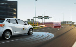 Ein EURO NCAP-Testauto fährt auf der Autobahn vor einer Linkskurve hinter einem Auto her. Der Kurvenradius wird im Bild grafisch angezeigt.