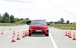 Rotes Auto testet auf einem Übungsgelände die Assistenzsysteme, Pylone begrenzen die Fahrspur.