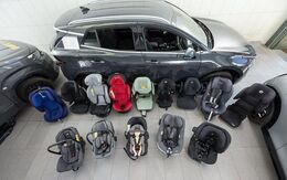 Kindersitze in unterschiedlichen Größen und Farben stehen am Boden einer Testhalle.