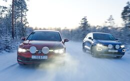 2 Autos fahren auf schneebedeckter Fahrbahn in Winterlandschaft, am Kennzeichen der beiden Autos steht Test.